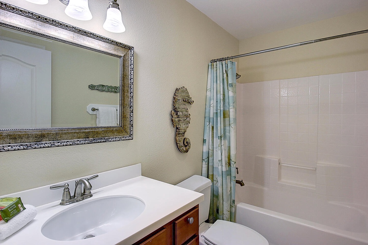 Refresh in your private bathroom with coastal charm, featuring a soothing tub-shower combo and elegant vanity for your daily routine.