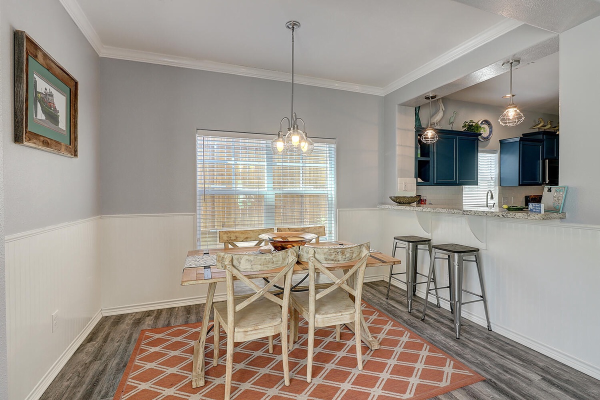 Gather around your bright dining space where morning coffee and evening meals feel special under charming pendant lighting.