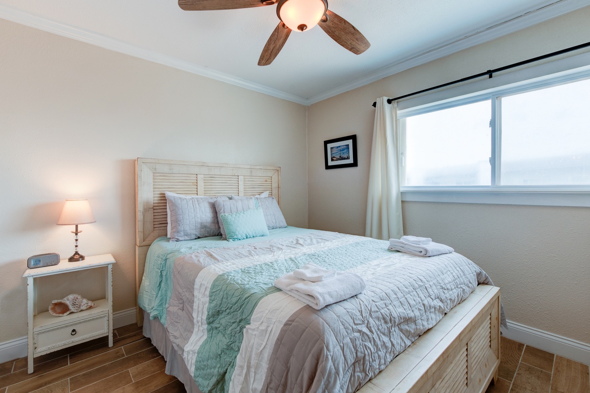 Drift into peaceful dreams in your cozy bedroom, where soft coastal linens and gentle ceiling fan breezes create the perfect retreat.