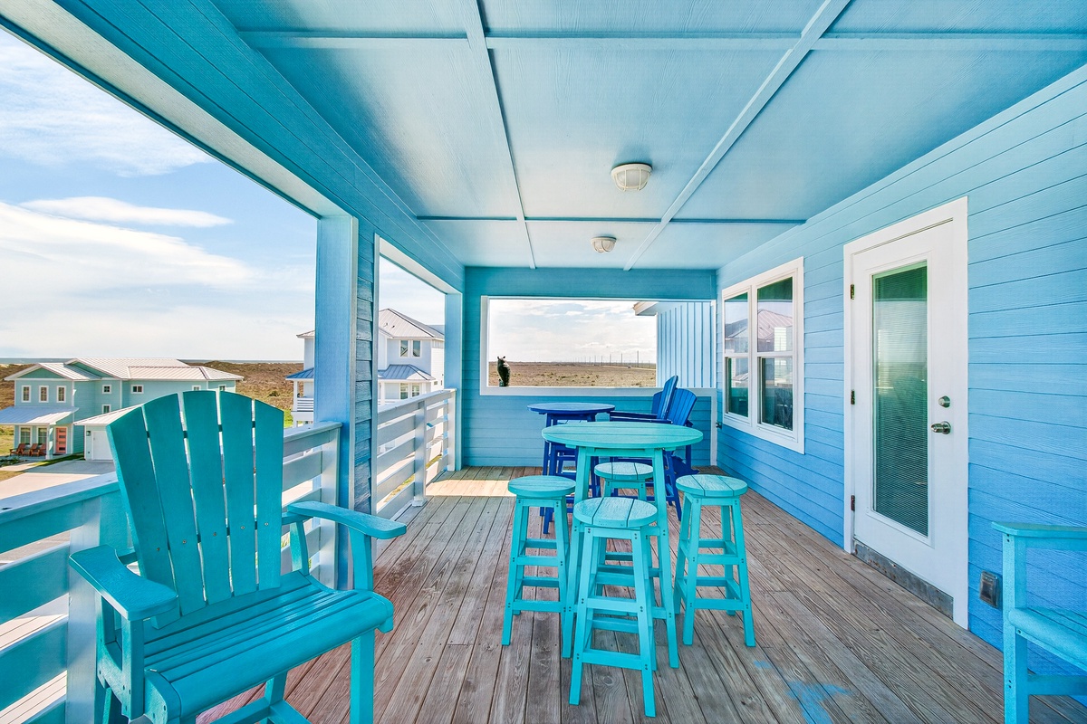 Unwind on your vibrant turquoise deck with ocean views, perfect for morning coffee or evening cocktails in this coastal paradise.