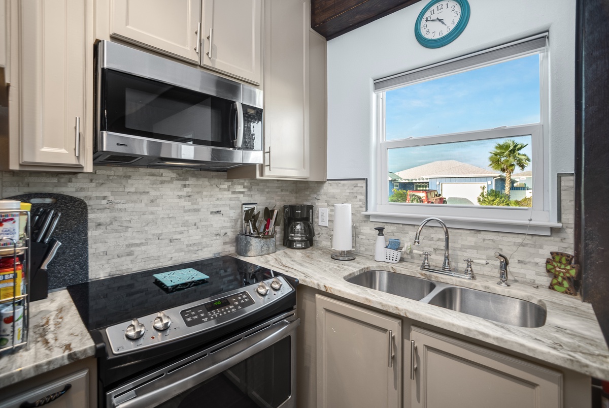 Cook with ease in this bright kitchen featuring modern appliances and scenic views through the window.