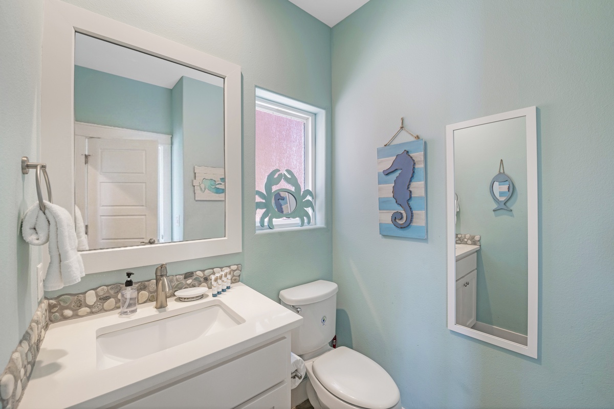 This bright bathroom features a spacious vanity, cheerful coastal décor, and plenty of space to get ready for the day.