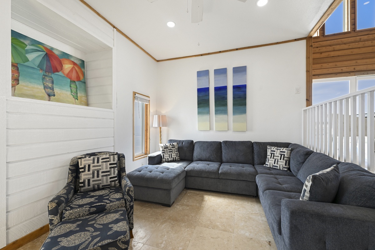 Relax in a spacious, coastal-inspired living room with plush seating and natural light.