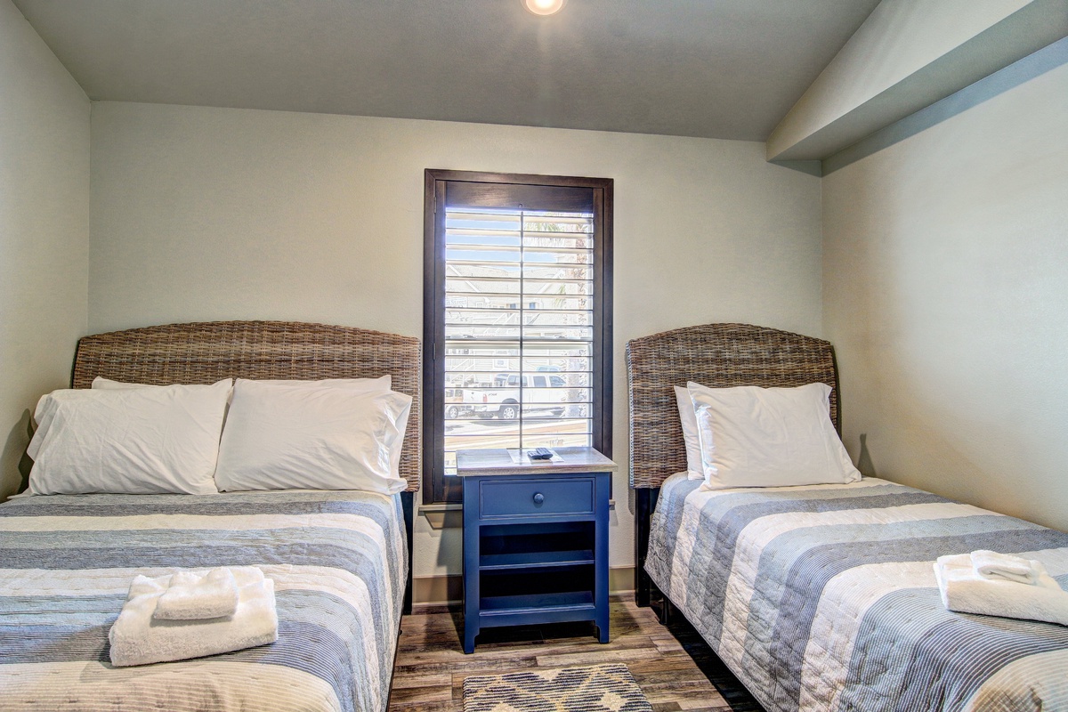 Sink into comfort in your twin bedroom, where wicker headboards and soft linens create a coastal vibe. Fresh towels await your arrival.