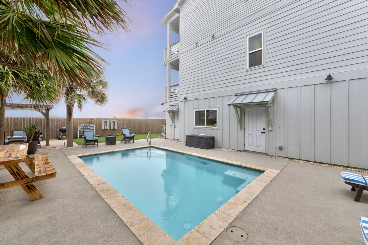 Your private pool awaits with loungers and tropical palms creating the perfect backyard escape for relaxation and fun.