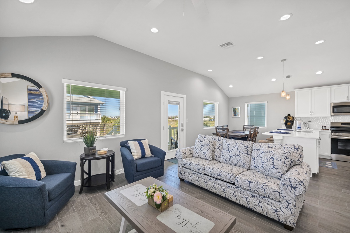 Sink into comfort in your bright, open living space with coastal-inspired furnishings and seamless kitchen access.