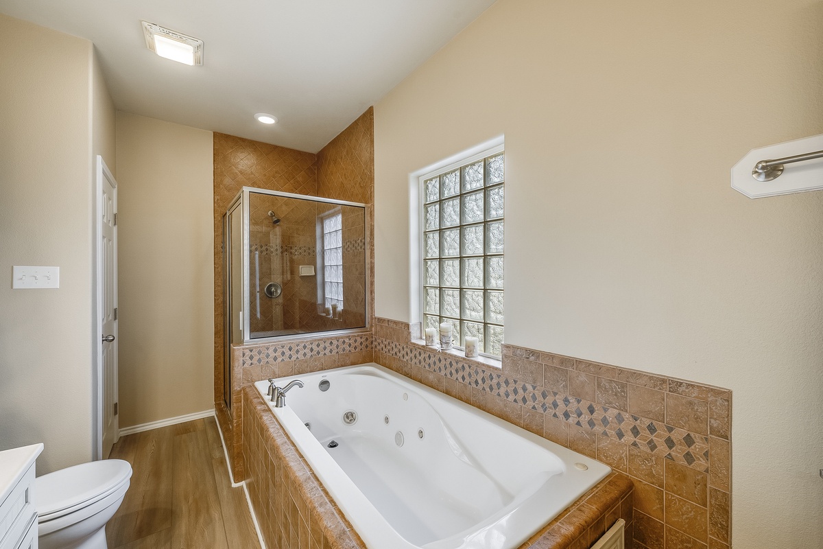 Luxurious bathroom with jetted tub and glass-enclosed shower where you can soak away stress after busy days exploring.