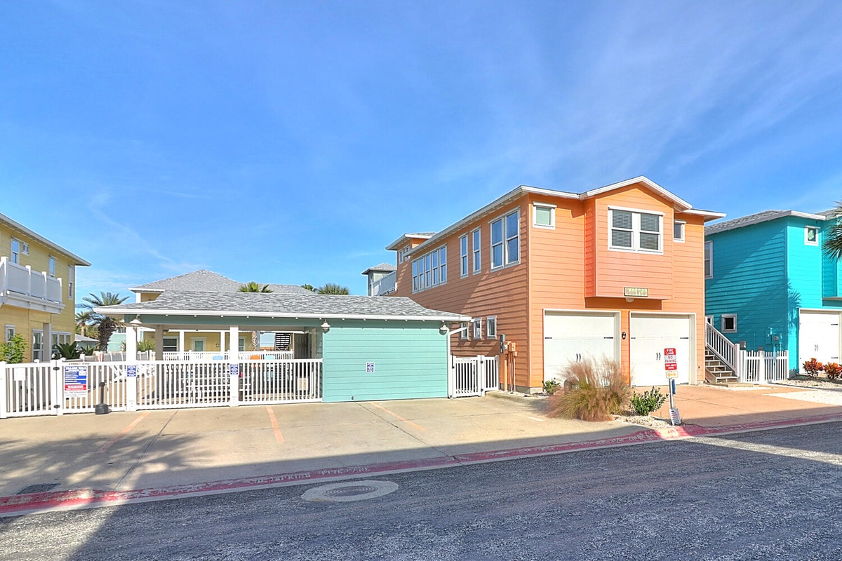 Colorful beach houses line this coastal neighborhood, featuring bright orange and turquoise facades with tropical charm.
