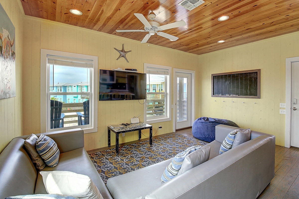 Relax in your cozy living space with beautiful wood ceilings, comfortable seating, and peaceful neighborhood views.