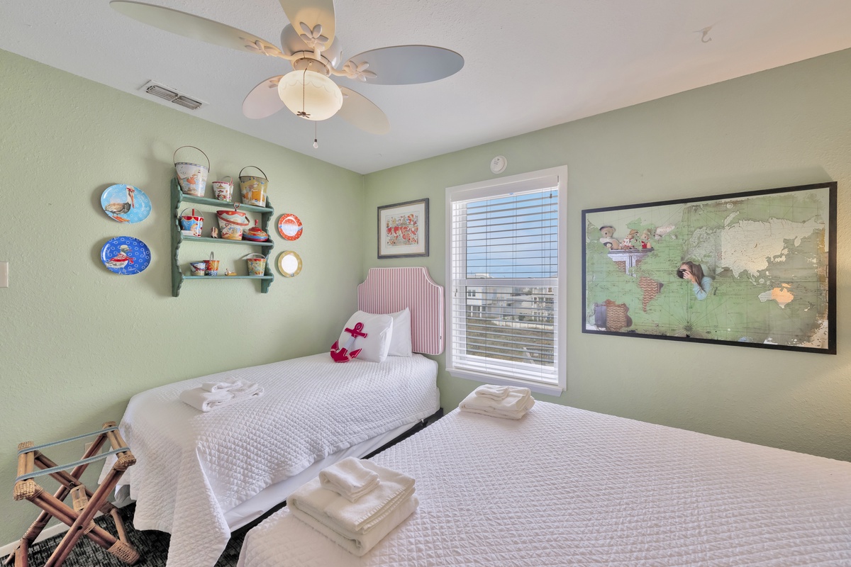 Sleep soundly in your cozy twin bedroom, complete with soft linens, a gentle ceiling fan, and charming travel-themed decor to inspire dreams.