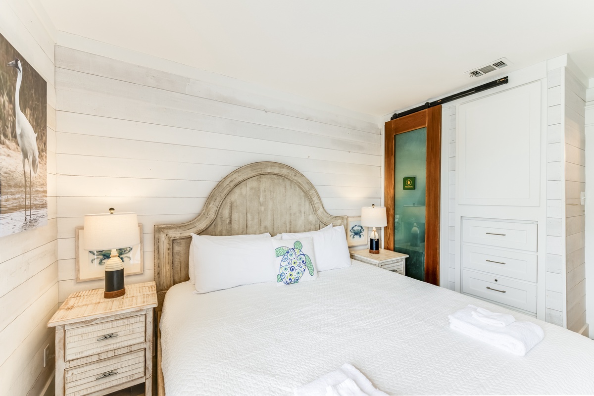 Sink into crisp white linens and let the coastal charm of shiplap walls and vintage-inspired furnishings wrap you in comfort. Your serene retreat awaits, complete with thoughtful details and a peaceful ambiance.