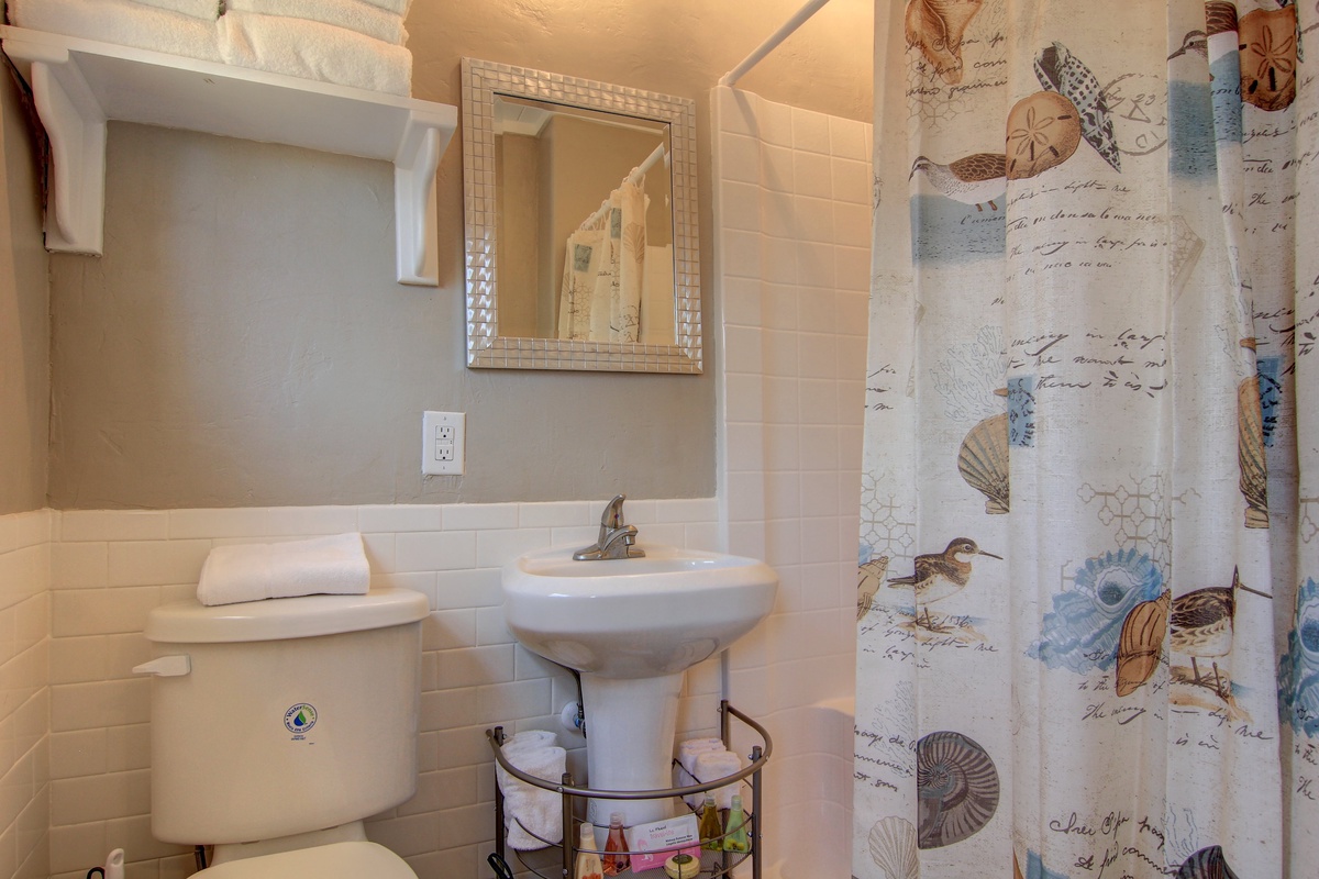 Your private bathroom features coastal charm with seashell decor and fresh towels, creating a peaceful seaside retreat.