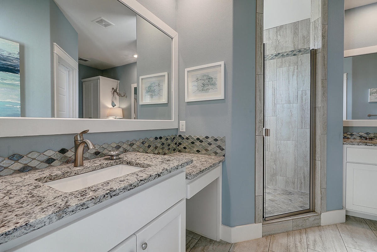 Your luxurious bathroom sanctuary features elegant granite countertops, mosaic tile accents, and a spacious glass shower—perfect for unwinding after your adventures.