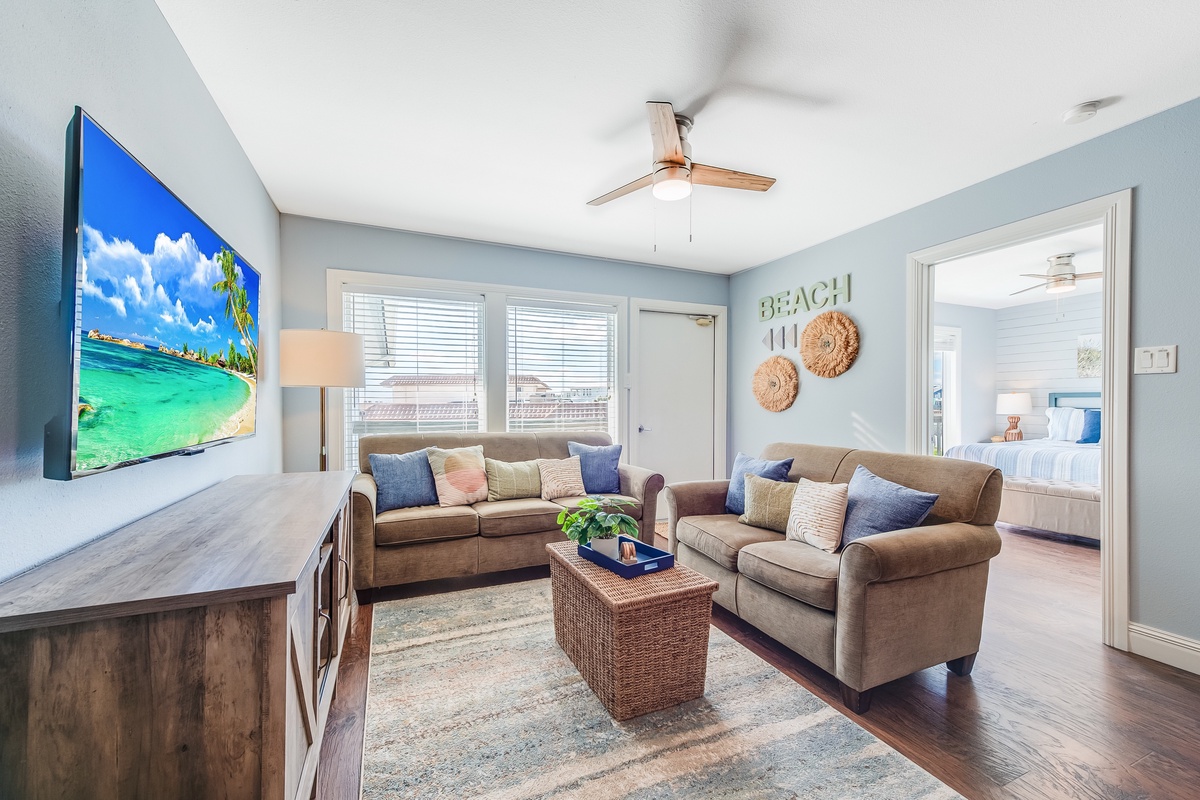 Sink into plush sofas and unwind in your spacious living room, where coastal décor and a large TV create the perfect retreat.