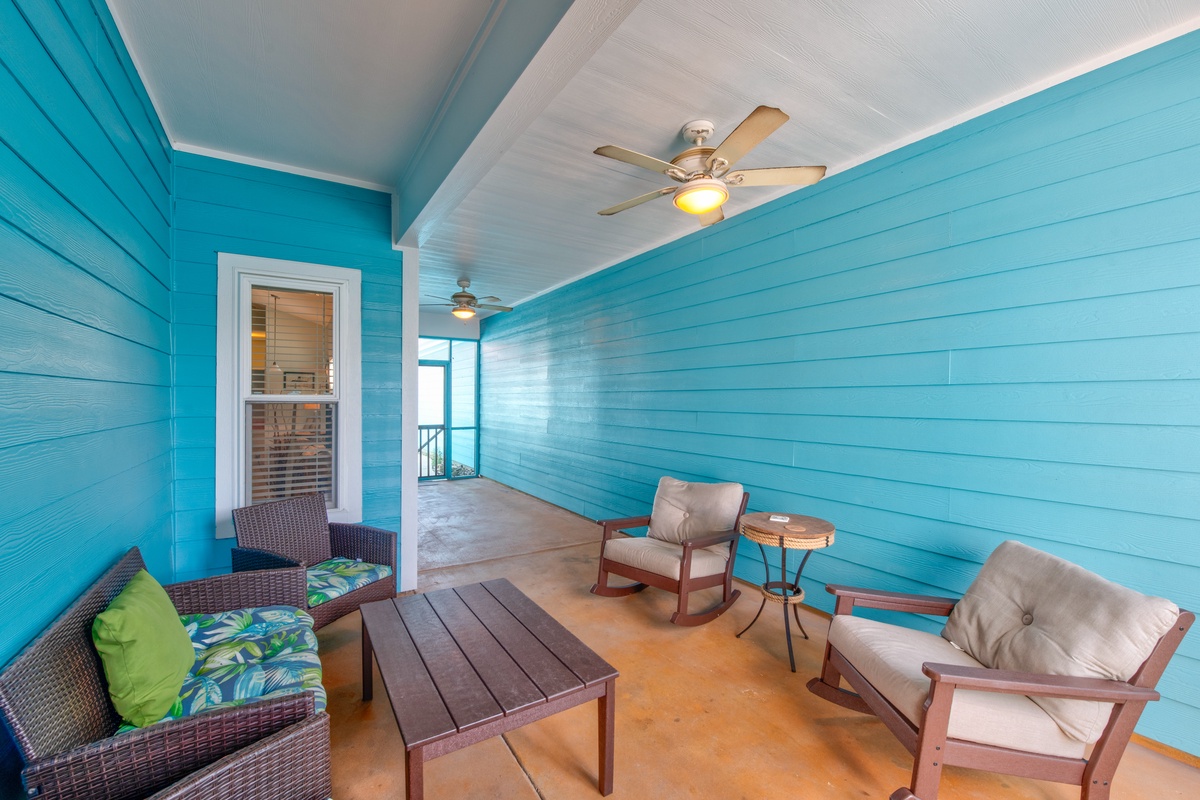 Unwind on your vibrant turquoise porch with comfortable seating and gentle ceiling fans creating perfect breezes.