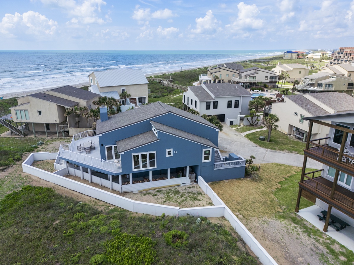 Stunning beachfront property situated steps from pristine coastline with neighboring beach homes in peaceful residential setting.