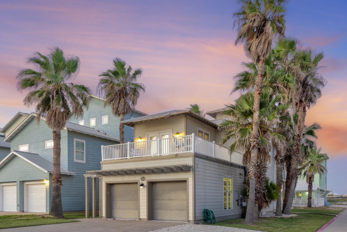 Tropical paradise awaits at this stunning beachside retreat, where swaying palm trees frame colorful coastal architecture under painted sunset skies.