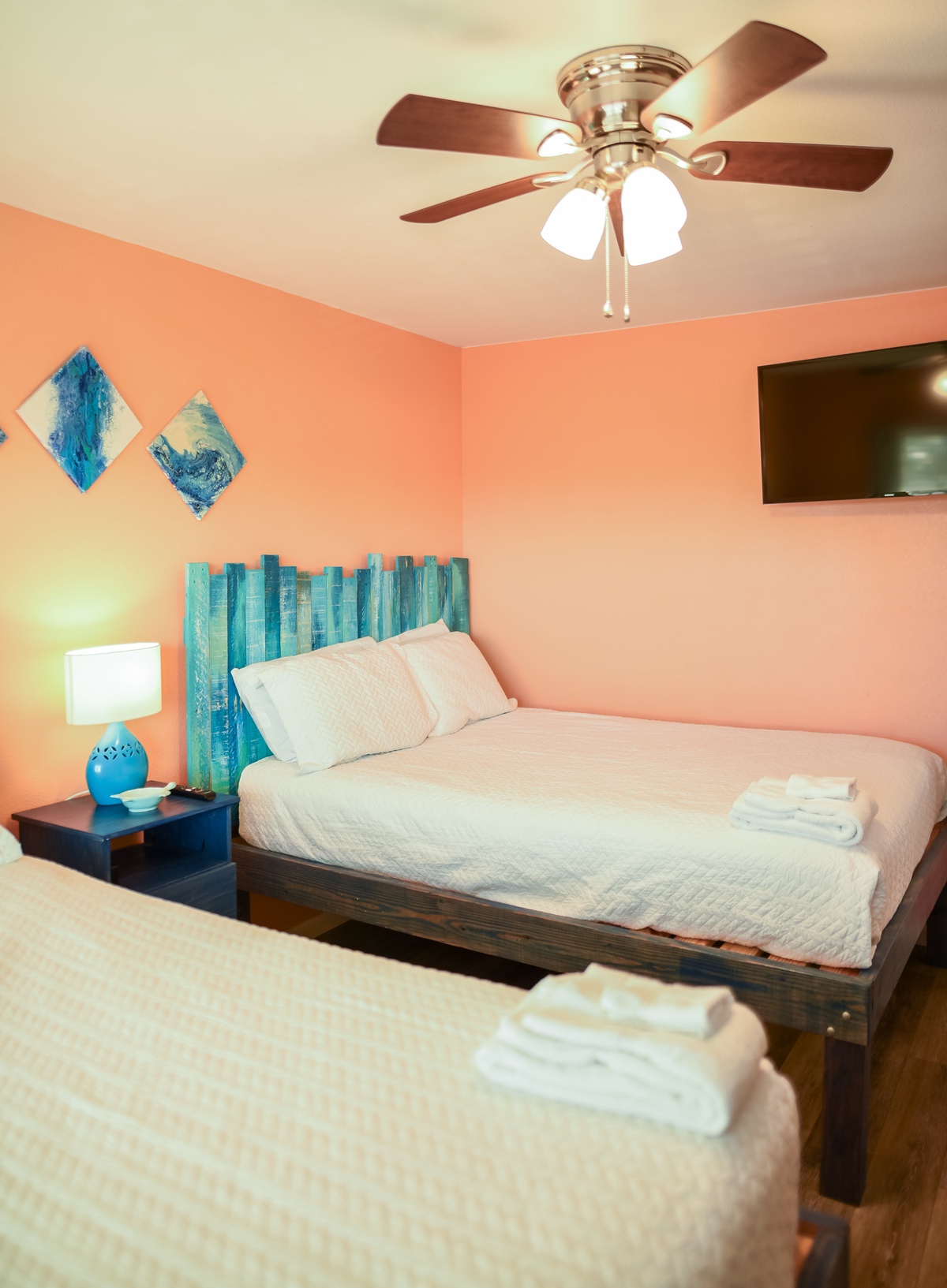 Relax in your coastal-themed bedroom with ocean-blue accents, ceiling fan, and flat-screen TV for ultimate comfort.
