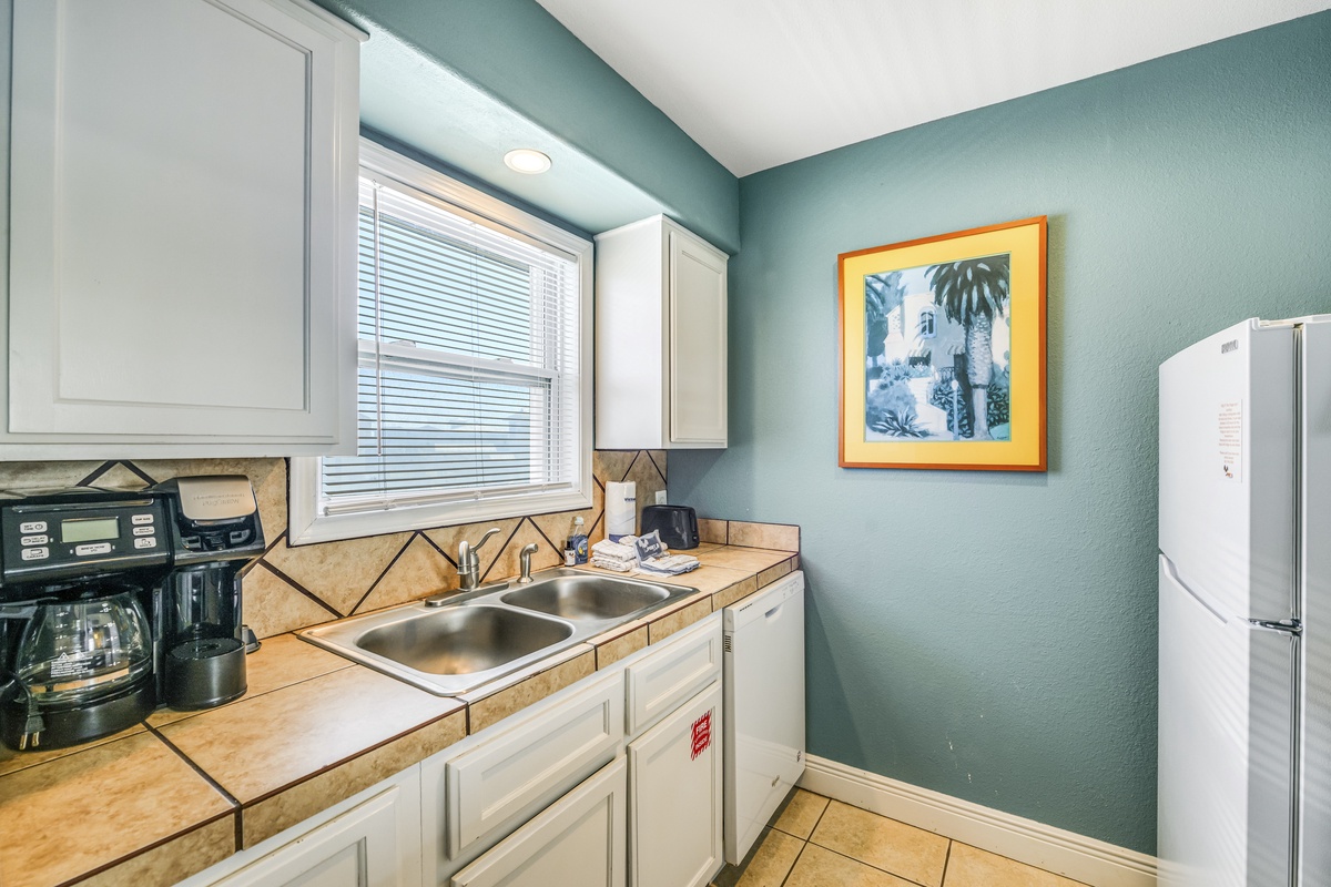 Your fully equipped kitchen awaits with everything needed to prepare meals, from morning coffee to family dinners in this charming coastal-themed space.