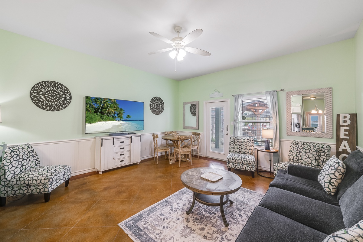 Relax in this bright, stylish living space with comfy seating, large TV, and charming coastal decor that creates your perfect vacation retreat.
