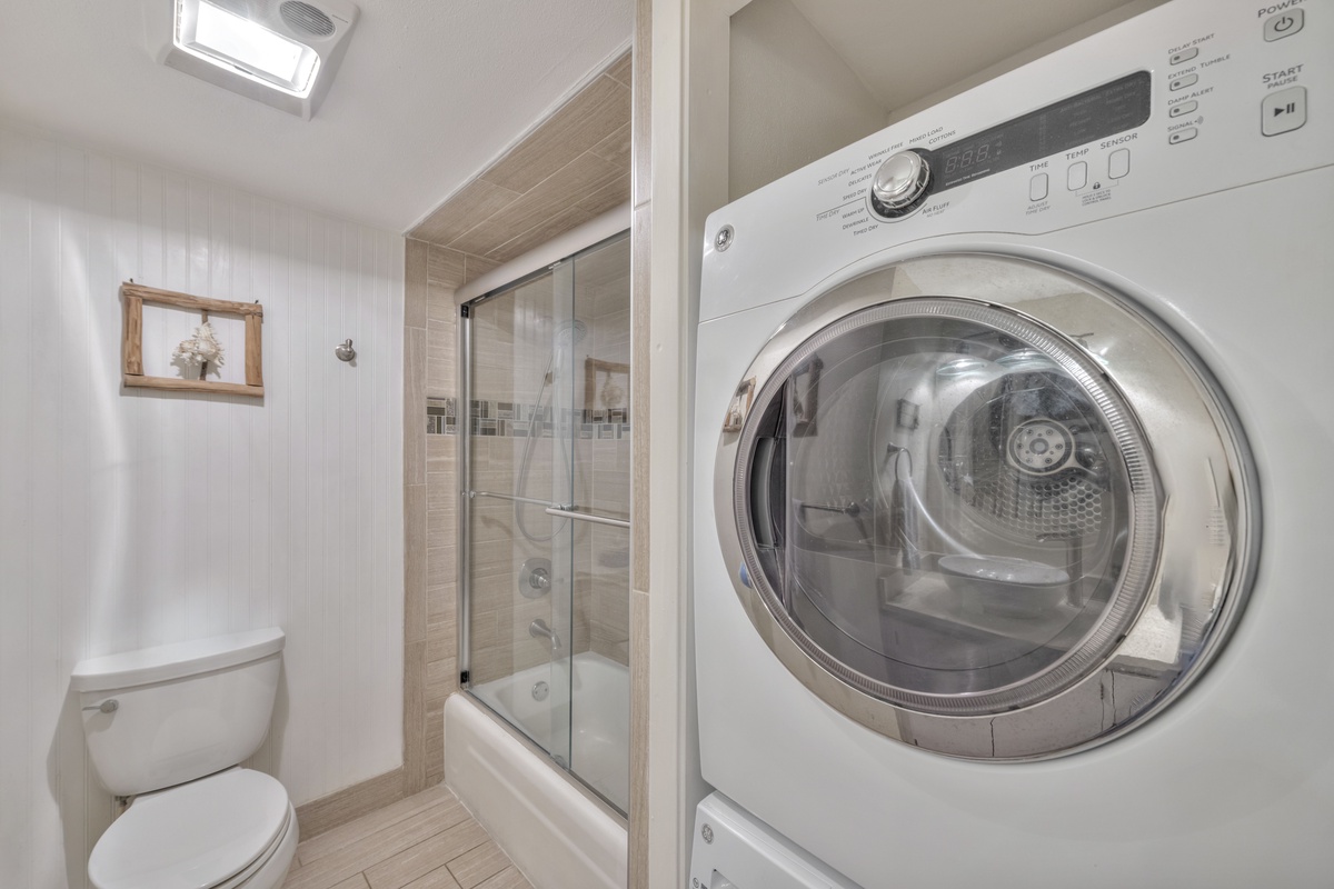 Your bathroom features a glass-enclosed shower, modern fixtures, and convenient in-unit laundry for effortless travel comfort.