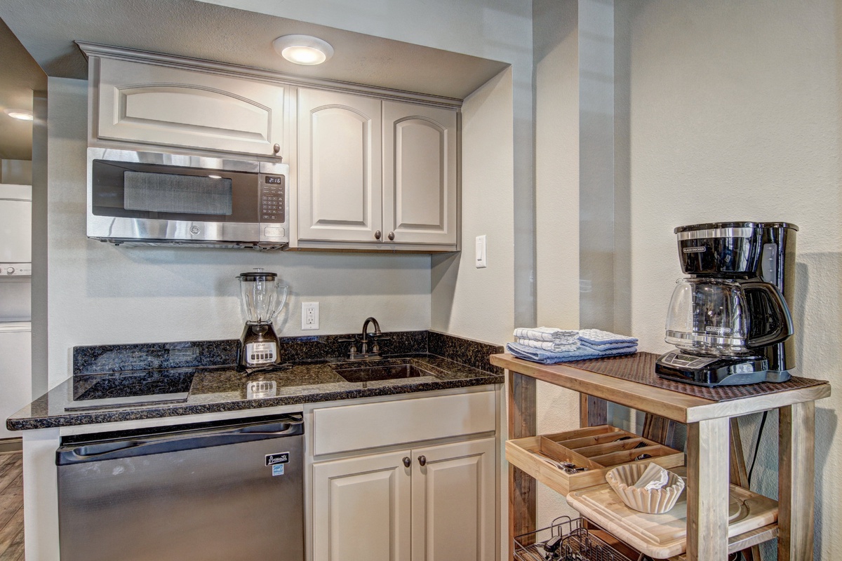 Your fully equipped kitchen features granite countertops, stainless steel appliances, and a cozy coffee station—perfect for preparing meals during your stay.