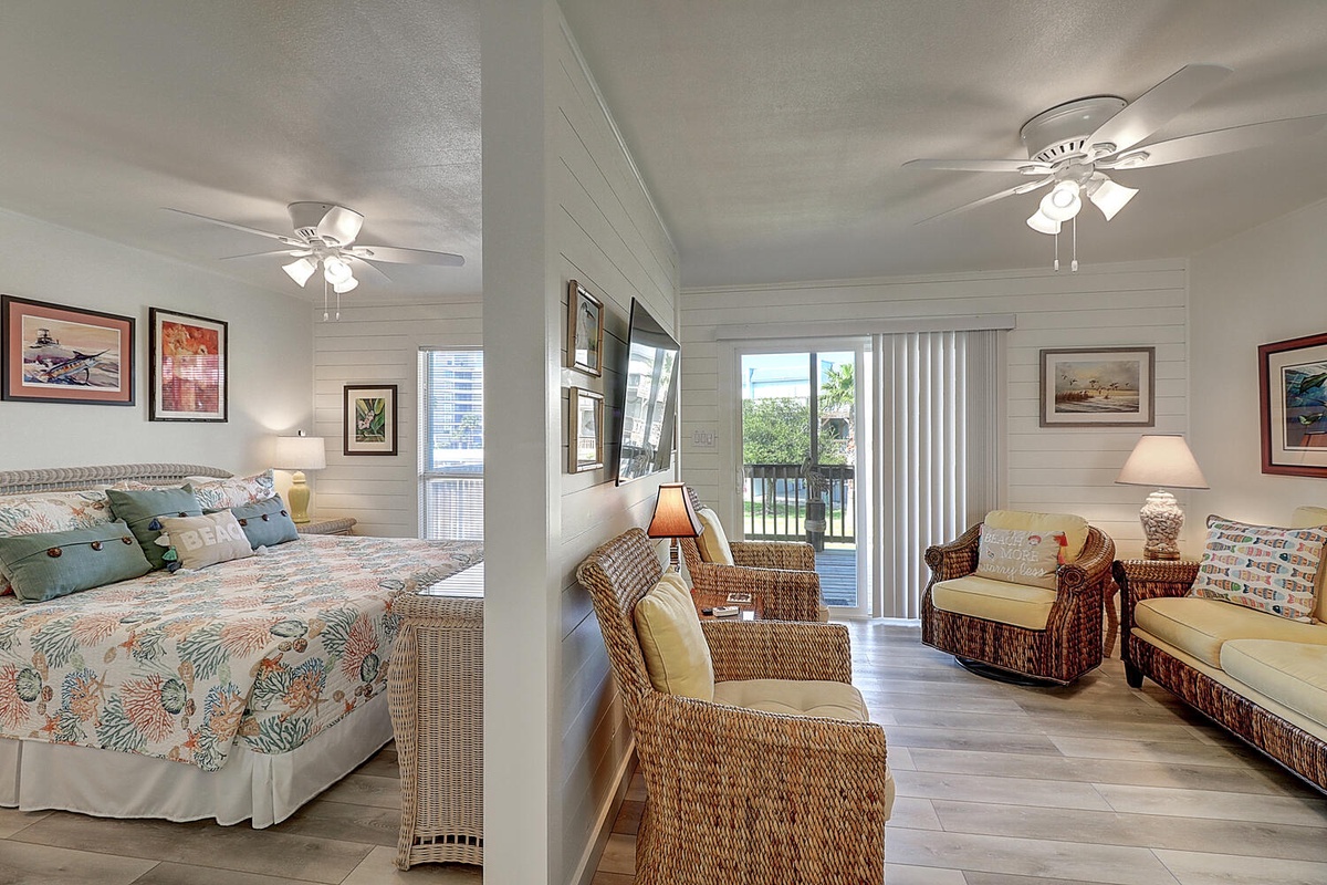 Relax in your coastal-themed suite featuring comfortable wicker seating and cheerful decor, all bathed in natural light.