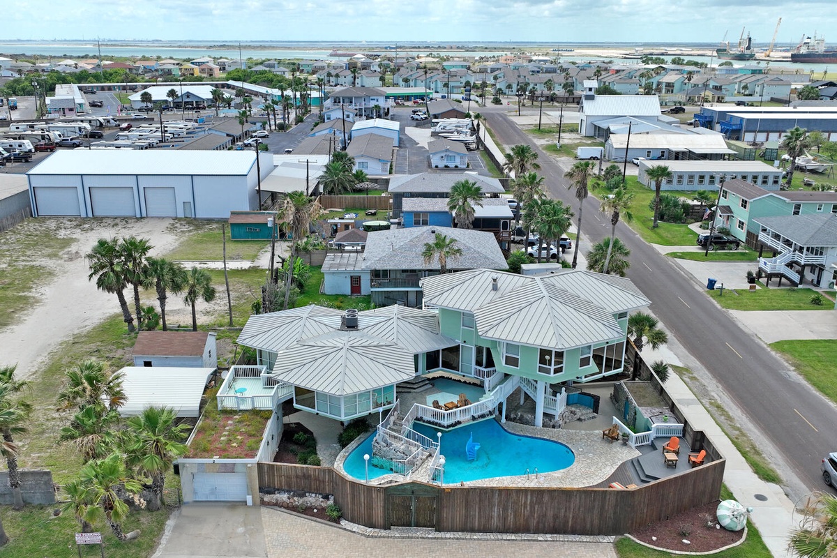 Coastal beach house with private pool and palm trees in quiet neighborhood setting.