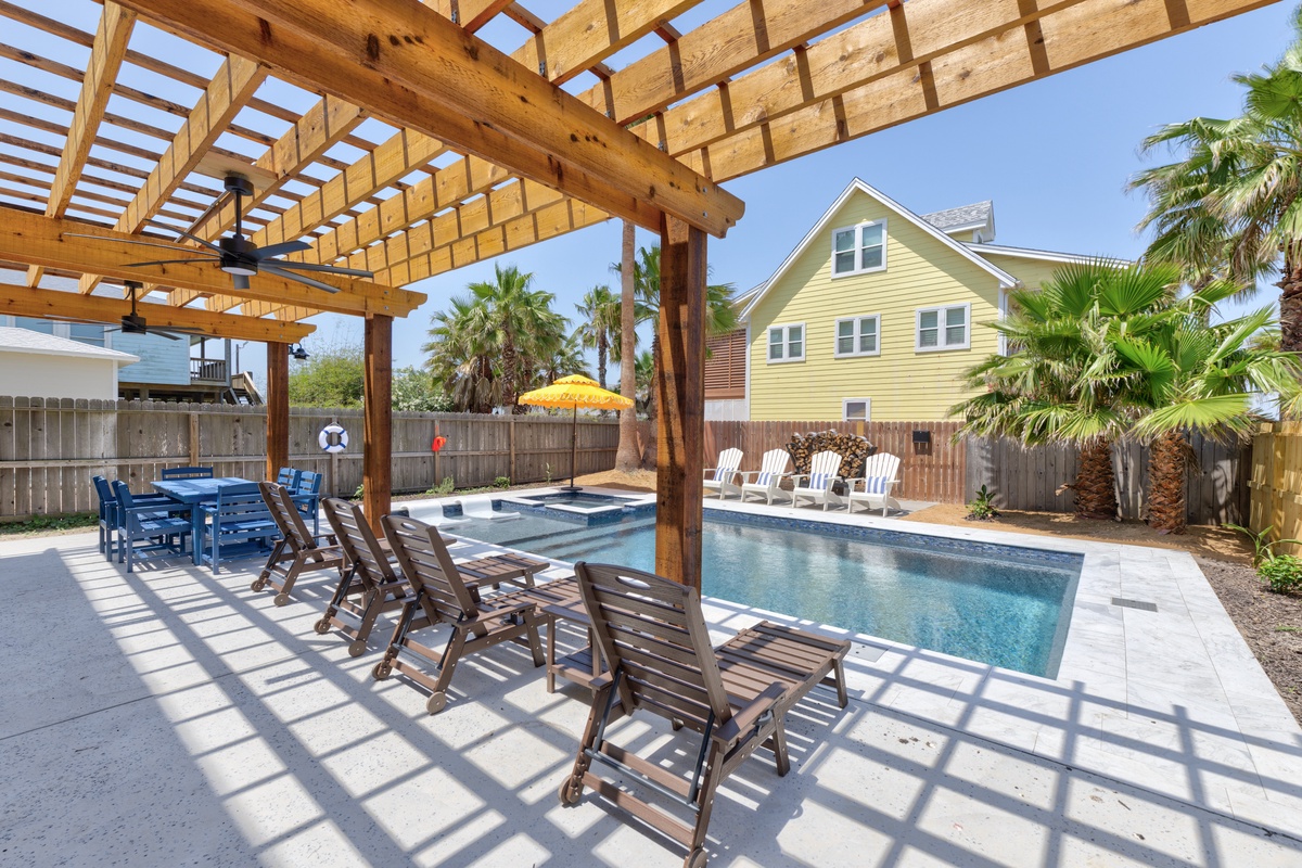 Relax under your private pergola beside the sparkling pool, where warm sunshine filters through wooden slats creating perfect shade.