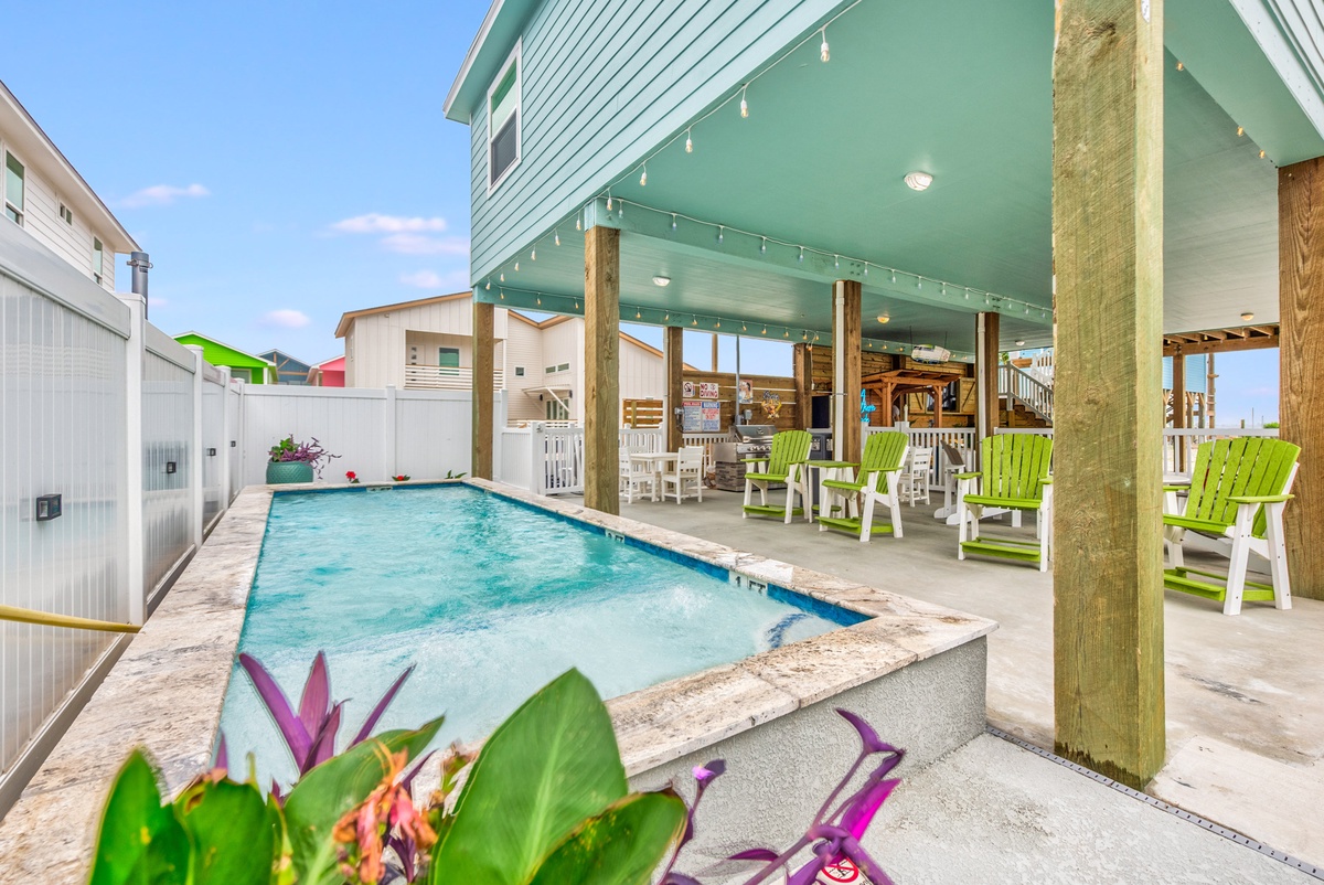 Dive into your private pool oasis, where vibrant green chairs await poolside lounging under twinkling lights.