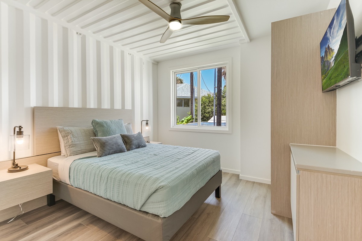 Your tranquil bedroom sanctuary features coastal blues and natural wood, with a ceiling fan keeping you cool during peaceful nights.