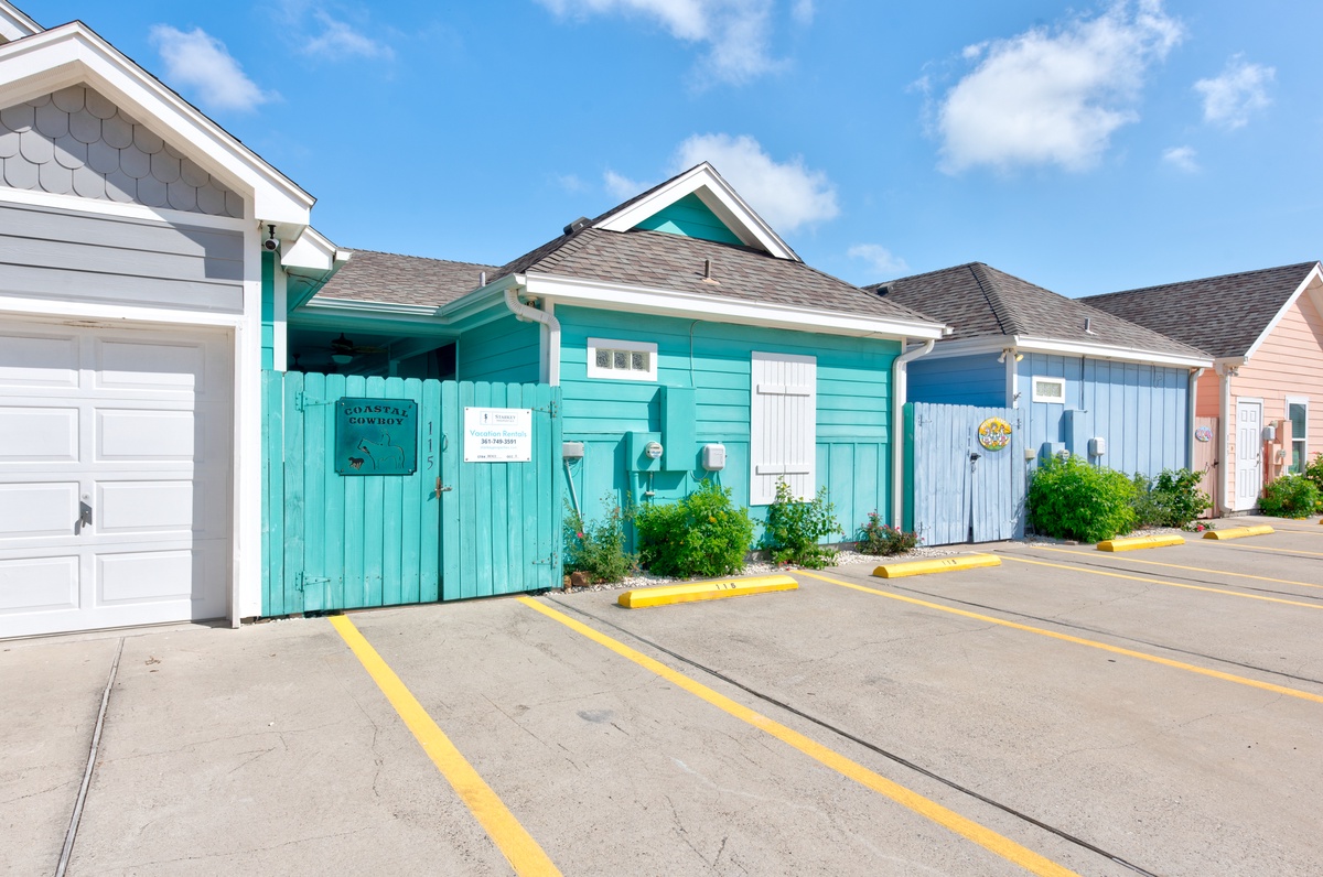 Charming coastal cottages with vibrant turquoise and blue facades create a delightful beachside atmosphere for your stay.