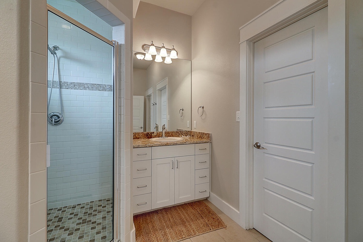 Step into your beautifully appointed bathroom with elegant vanity, spacious shower, and warm lighting for the perfect start to your day.
