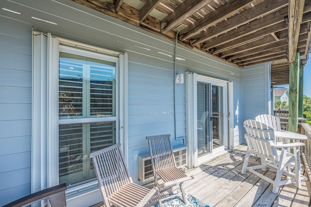 Relax on your private deck with comfortable seating and peaceful views through elegant windows.