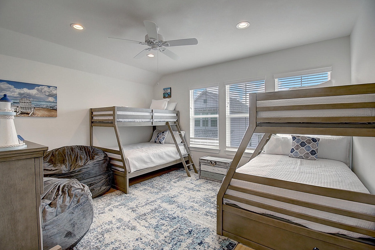 Your kids will love this spacious bunk room with comfortable beds, soft lighting, and plenty of space to unwind after beach adventures.