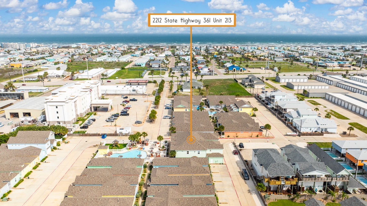 Aerial view of coastal community on State Highway 361, showing residential neighborhoods and nearby beach access for guests.