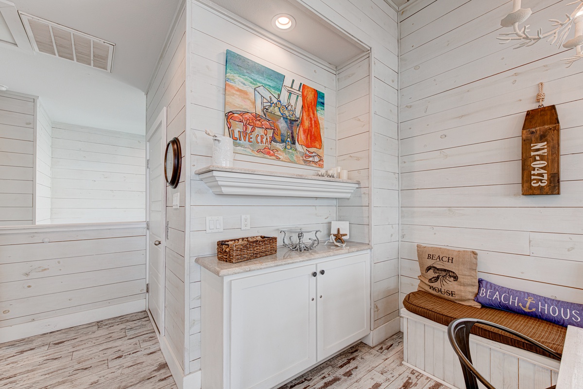 Step into your charming coastal-themed entryway, where white shiplap walls and beach artwork create the perfect seaside welcome.