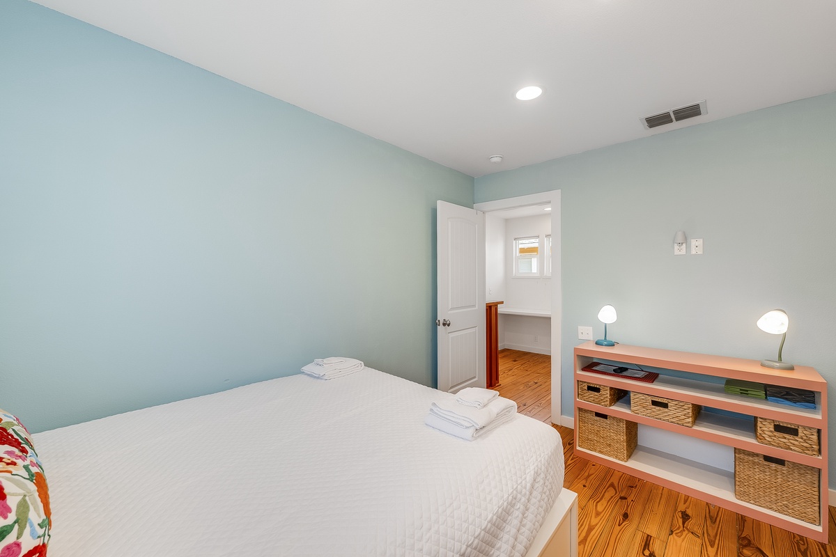 Unwind in your serene bedroom with soft mint walls and warm hardwood floors creating the perfect retreat after your day of exploring.