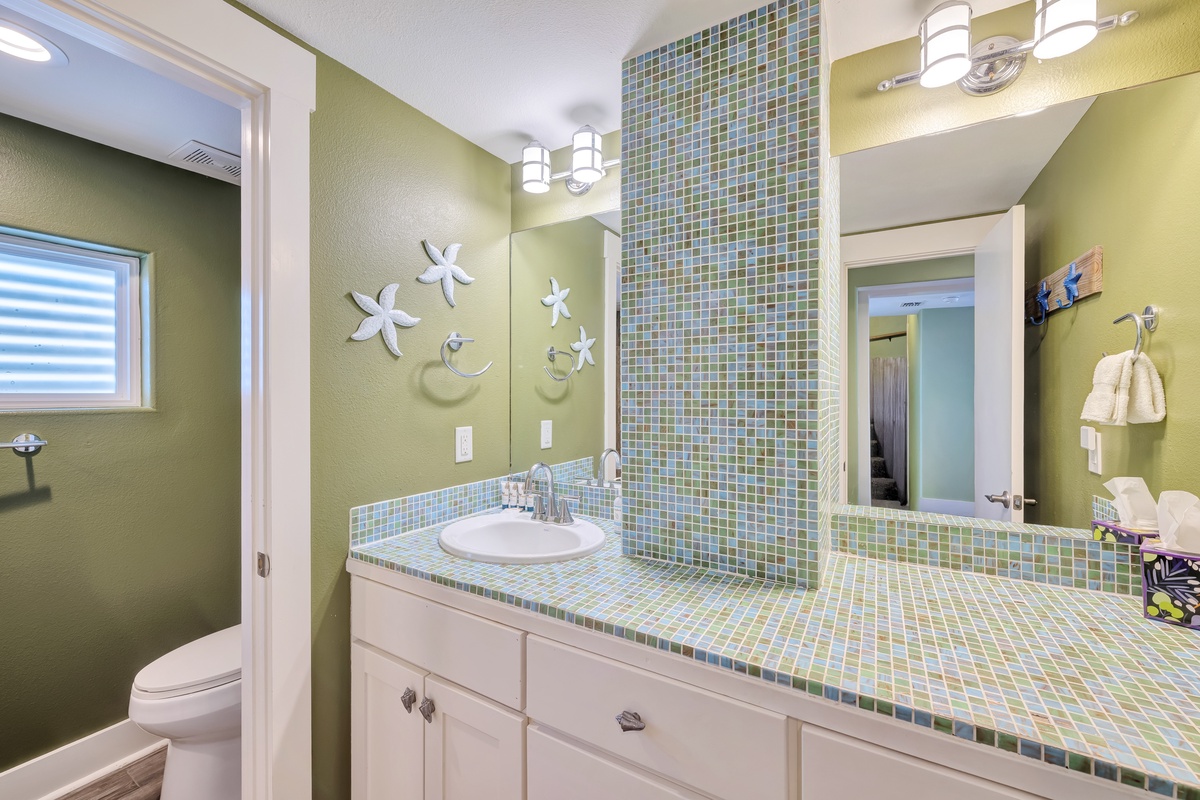 Refresh in your bright coastal bathroom featuring charming starfish accents, sparkling mosaic tiles, and thoughtful design touches that make your daily routine feel like a spa retreat.