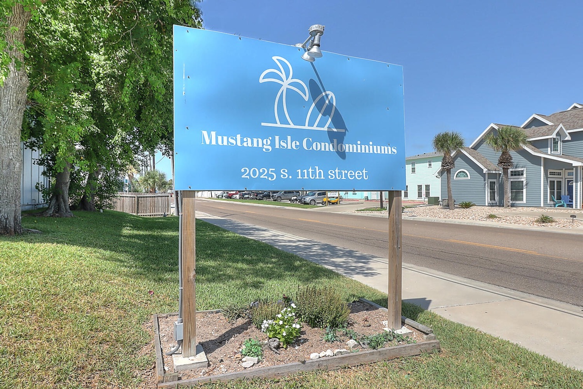 Property entrance sign marking your arrival at Mustang Isle Condominiums on S. 11th Street.