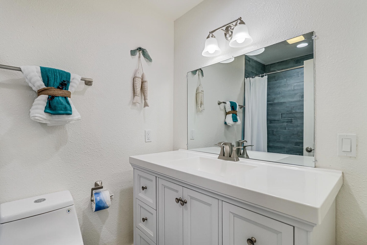 Freshen up in your pristine bathroom featuring teal accents, stylish tile work, and thoughtful touches that make your morning routine feel luxurious.