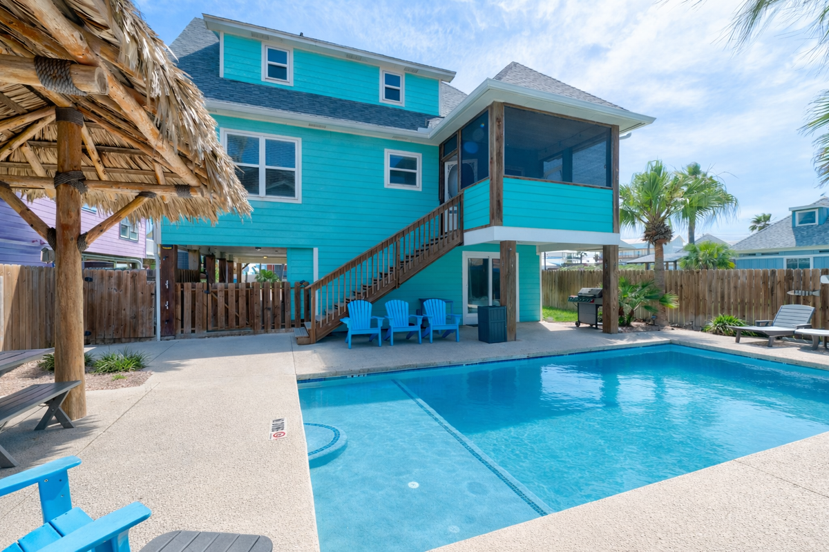 Your private pool paradise awaits with tropical blue waters, shaded tiki hut, and coastal charm at this vibrant beachside retreat.