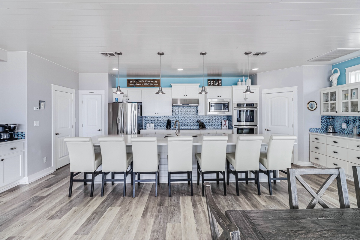 Your dream kitchen awaits with a spacious island for eight, gleaming appliances, and coastal blue accents that create the perfect gathering spot for your group.