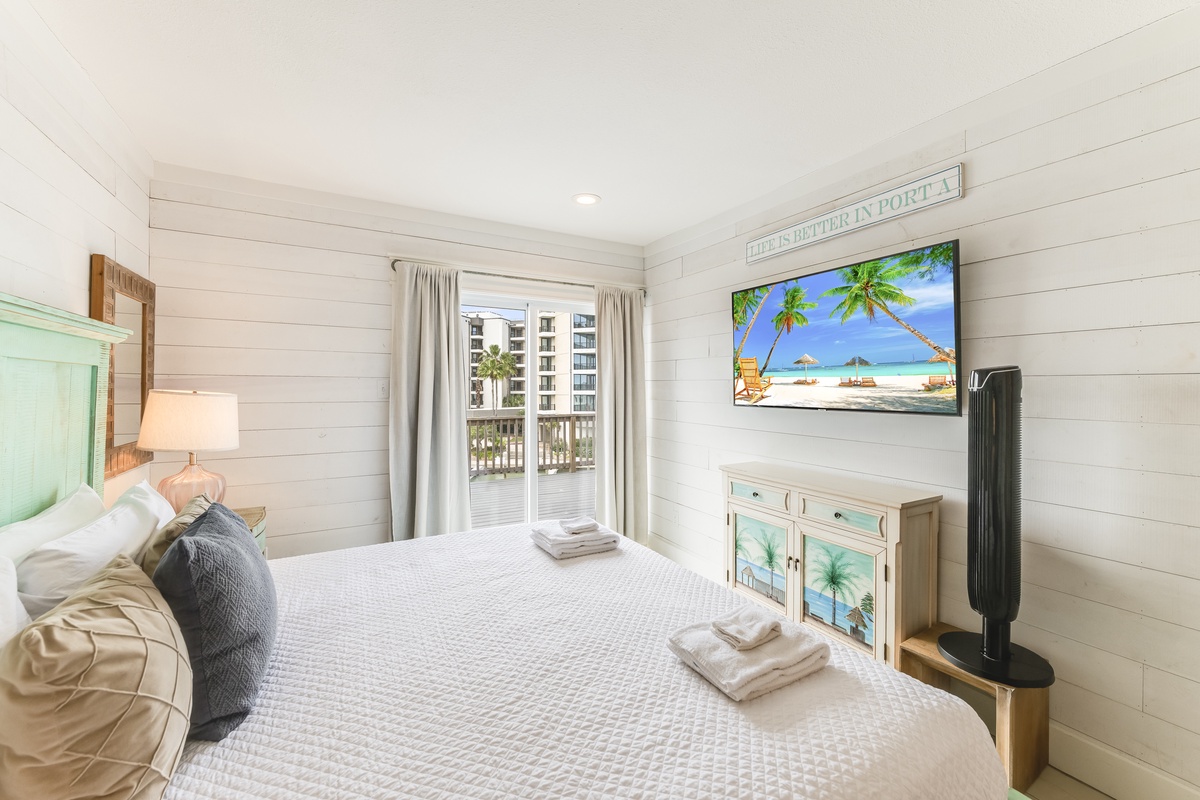 Drift off in this serene coastal bedroom, where soft shiplap walls and crisp linens create your peaceful retreat. Step out to your private balcony and let the sea breeze welcome you home.