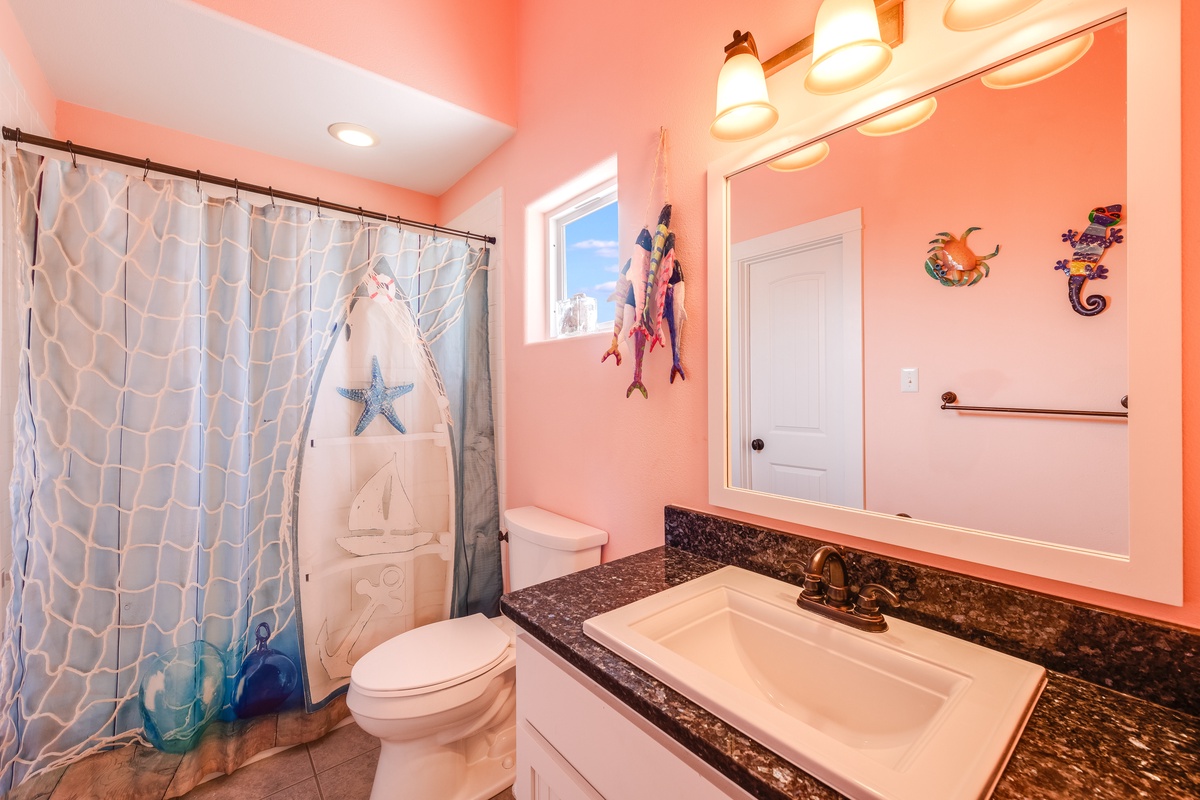 Dive into coastal charm in your vibrant bathroom, featuring playful sea-themed decor and warm coral walls that make every moment feel like a beach getaway.