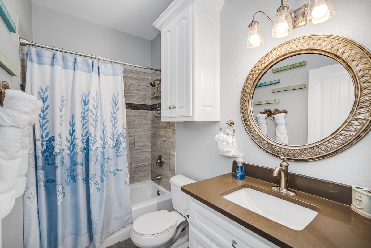 Your elegant bathroom features a luxurious soaking tub, stylish vanity with quartz countertop, and beautiful coastal-themed decor to refresh after your adventures.