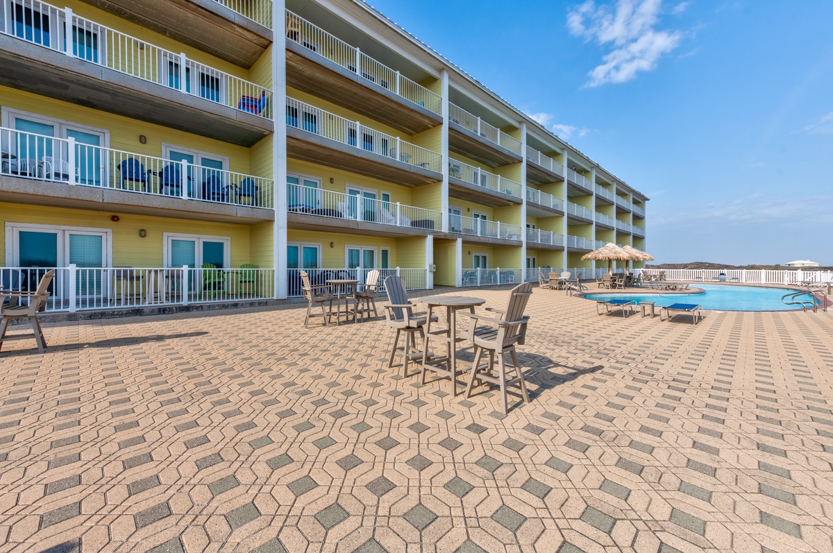 Oceanfront property featuring multiple floors of guest accommodations with private balconies overlooking a spacious pool deck and beachfront location.