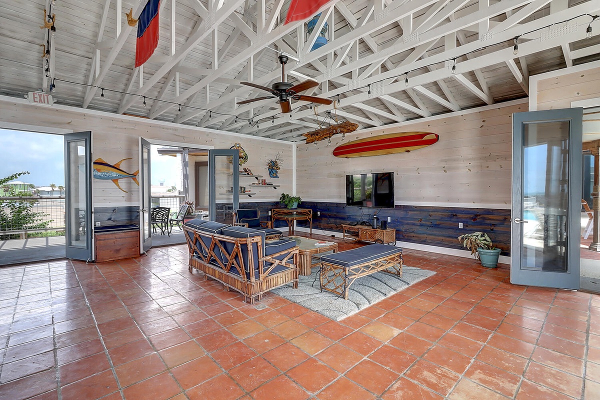 Relax in your spacious living room featuring soaring exposed beam ceilings, nautical décor, and bamboo furnishings.