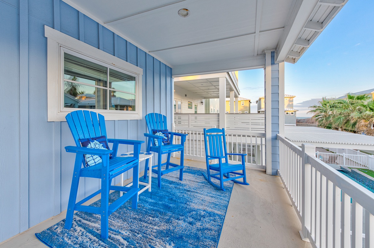 Your private balcony awaits with comfortable blue seating and views of the neighborhood, perfect for morning coffee or evening relaxation.