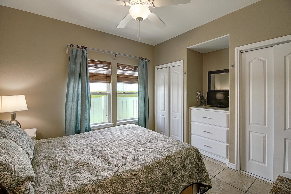 Settle into your peaceful bedroom with warm earth tones, natural light streaming through bamboo blinds, and all the storage you need.